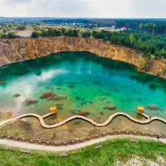 Piękne, turkusowe jezioro w kamieniołomie, z drewnianą kładką i altanką. Idealne miejsce, gdzie na weekend w Polsce dla miłośników natury.