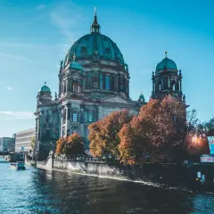 Berliński Dom na tle błękitnego nieba, z łodzią na rzece. Piękne miasta w Niemczech jesienią.