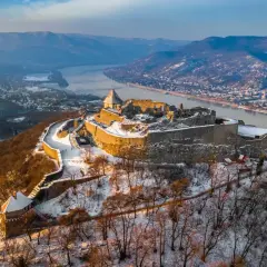 Zimowy krajobraz z górującym nad Dunajem **Wyszehrad**, ośnieżone ruiny zamku i malownicza dolina.