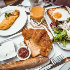 Pyszne śniadanie w Paryżu: omlet, croissant, jajko sadzone na grzance, sałatka, jogurt, dżem i bagietka. Idealne miejsce, gdzie zjeść w Paryżu.