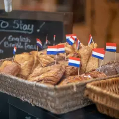 Koszyk pełen słodkości z holenderskimi flagami. Idealne miejsce, by sprawdzić, co zjeść w Amsterdamie.