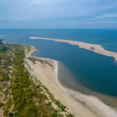 Piękny krajobraz polskiego wybrzeża Bałtyku z piaszczystą mierzeją i zielenią.