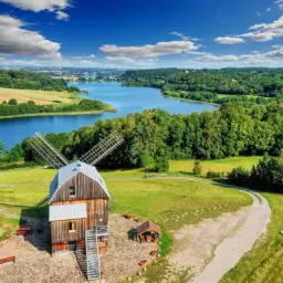 Wiatrak na Kaszubach, z którego słyną te malownicze tereny. Jezioro, lasy i pola tworzą sielski krajobraz.