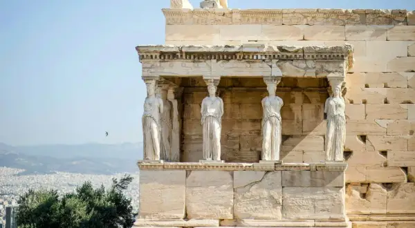 Erechtheion, świątynia Ateny, z kariatydami podtrzymującymi dach. W tle Ateny i góry.