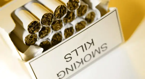 Otwarta paczka papierosów, na której widnieje napis "SMOKING KILLS". Zastanawiasz się, ile kosztują papierosy w Anglii?