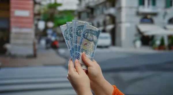 Ręce trzymają pięć banknotów po 1000 forintów. Tyle pieniędzy na 3 dni w Budapeszcie?