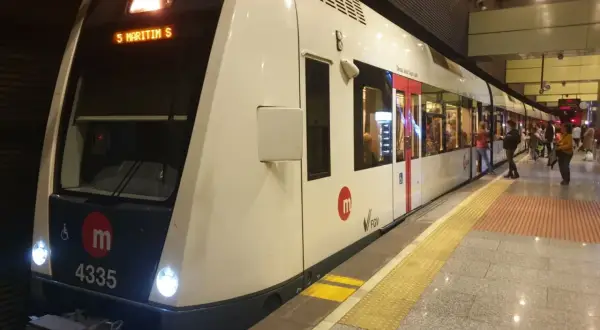 Nowoczesny pociąg metra w Walencji, numer 4335, stoi na peronie. Ludzie czekają na wejście.