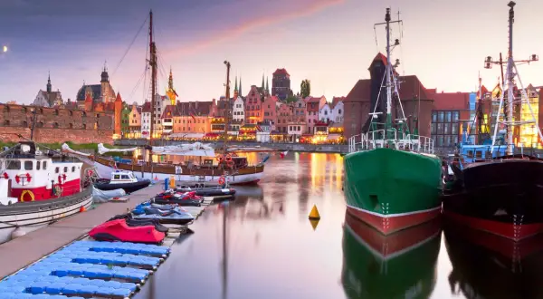 Port w Gdańsku o zachodzie słońca, idealne miejsce na jednodniowe wycieczki z Gdyni. Widoczne statki, kamienice i łodzie.