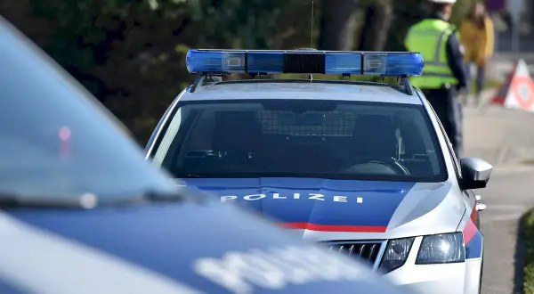Policyjne radiowozy z włączonymi sygnałami świetlnymi patrolują niebezpieczne dzielnice Wiednia.