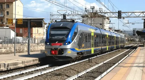 Nowoczesny pociąg wjeżdża na stację, przypominając miejski transport, jak neapol metro.