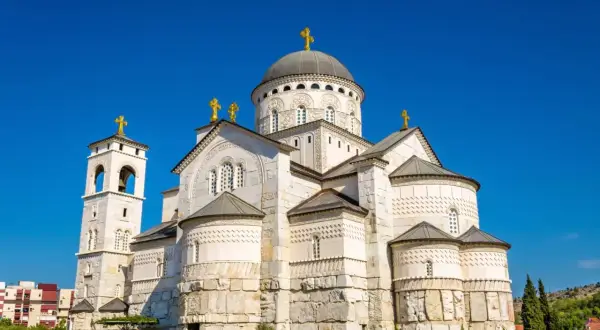 Majestatyczna cerkiew w Podgoricy, stolicy Czarnogóry, z dominującą kopułą i złotymi krzyżami.