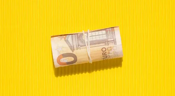 Zrolowana wiedeń waluta, banknot 50 euro, na żółtym, karbowanym tle.