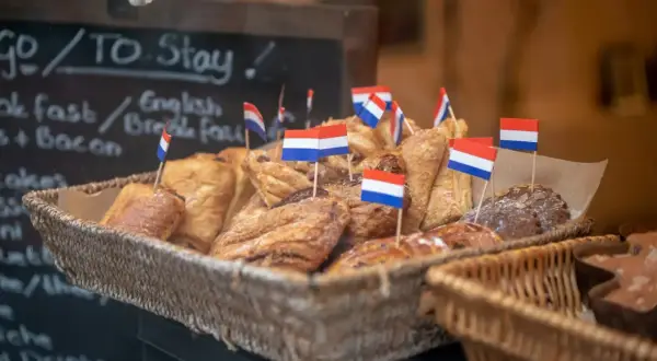 Koszyk pełen słodkości z holenderskimi flagami. Idealne miejsce, by sprawdzić, co zjeść w Amsterdamie.