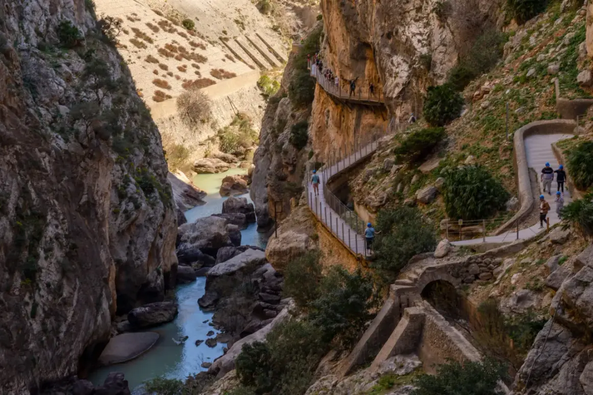 Wąwóz El Caminito del Rey w Sierra Nevada Hiszpania, z turystami na ścieżce zawieszonej nad rzeką.
