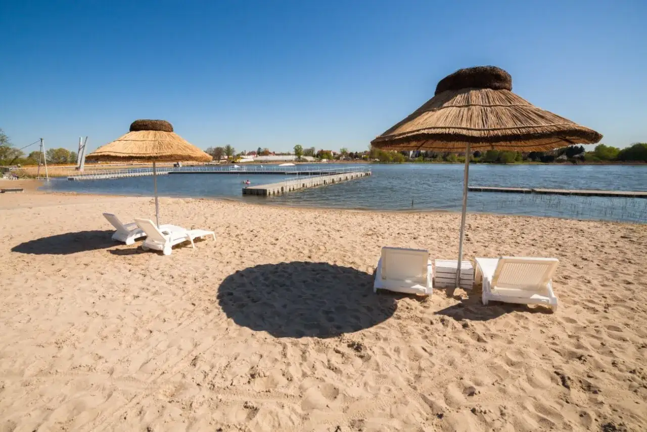 Słoneczne plaże nad Jeziorem Bodenskim zapraszają do relaksu. Leżaki i parasole czekają na plażowiczów.