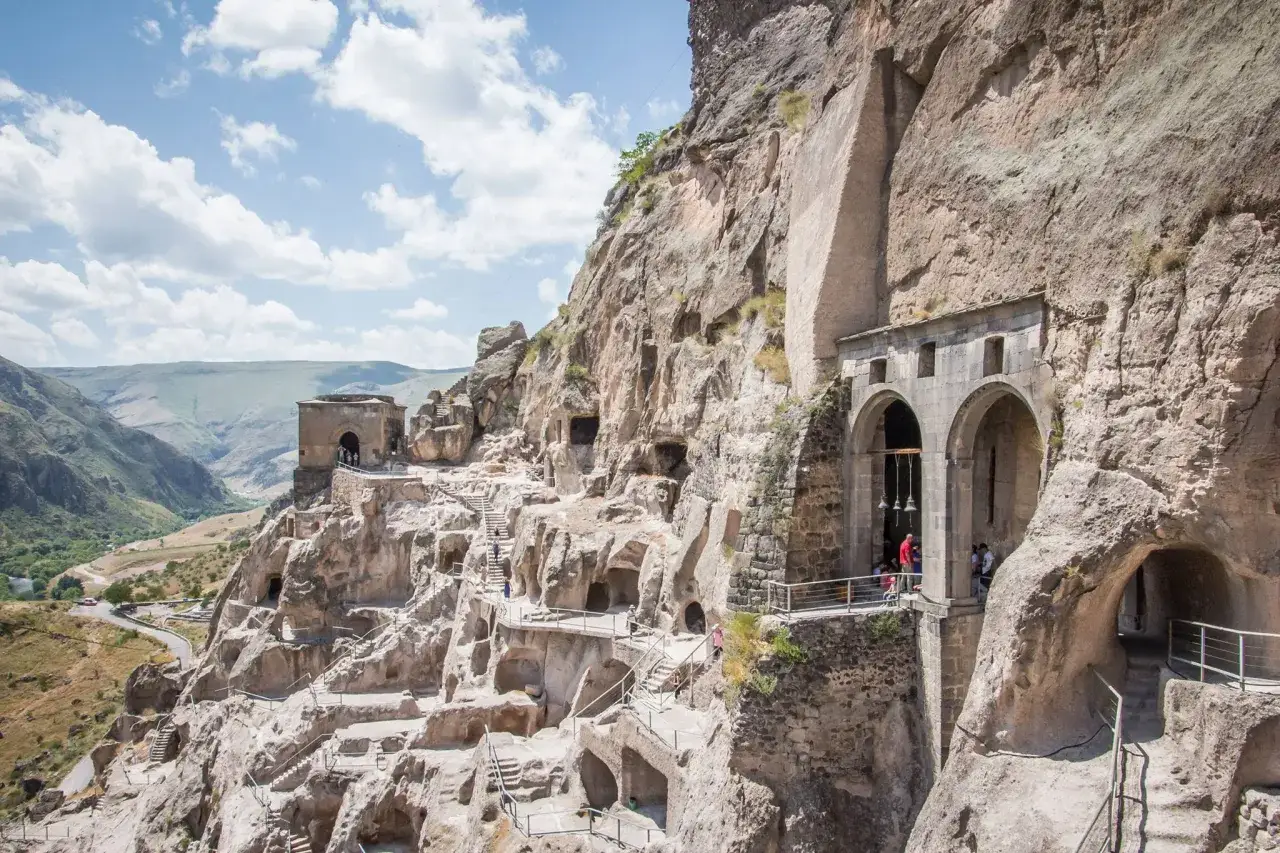 Gruzja najpiękniejsze miejsca: skalne miasto Vardzia, wykute w klifie, z licznymi jaskiniami i schodami.