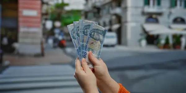 Ręce trzymają pięć banknotów po 1000 forintów. Tyle pieniędzy na 3 dni w Budapeszcie?