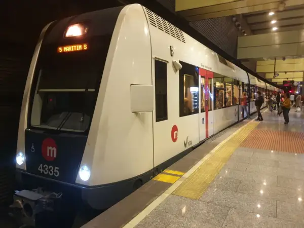Nowoczesny pociąg metra w Walencji, numer 4335, stoi na peronie. Ludzie czekają na wejście.