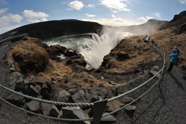 Wodospad Gullfoss na Islandii. Tłumy turystów podziwiają potęgę natury, tworząc malowniczy ruch drogowy na ścieżkach.