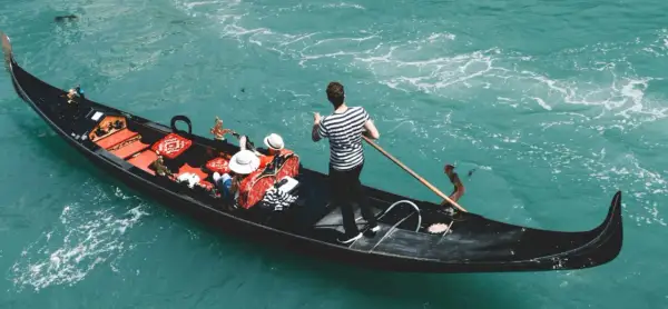 Gondola w Wenecji z pasażerami i gondolierem. Zastanawiasz się, ile kosztuje gondola w Wenecji?